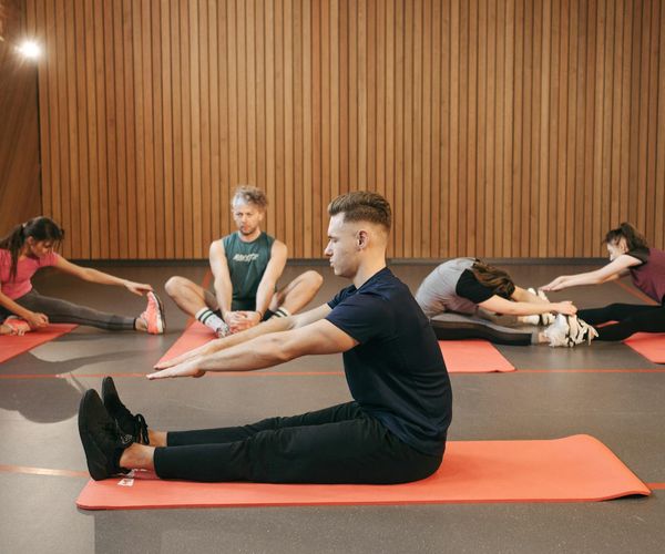 A small group of people practicing yoga in a well-lit studio.